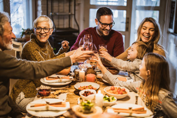 istock Happy multi-generation family toasting while having lunch in dining room. 1677709877