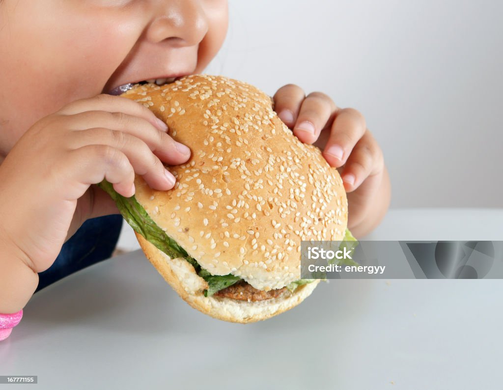 Piccolo ragazza caucasica mangiare Hamburger - Foto stock royalty-free di Bambino