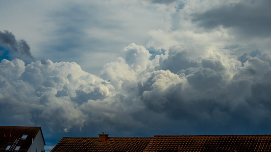 Sky sights, sunlit cumulonimbus over rooftops, thunder clouds