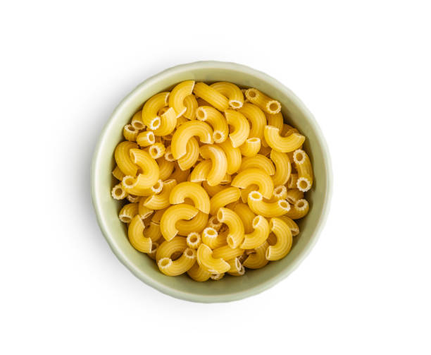 istock Raw macaroni pasta in bowl. Uncooked rigatoni isolated on white background. 1677728232