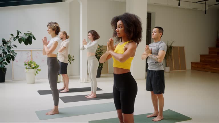 Sports team standing on yoga mats during training in studio