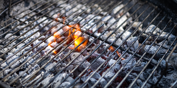 Close-up of hot coals burning on barbecue grill.
