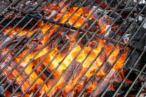 Close-up of hot coals burning on barbecue grill.