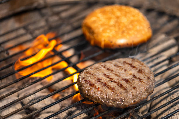 Close-up of burgers roasting on barbecue grill.