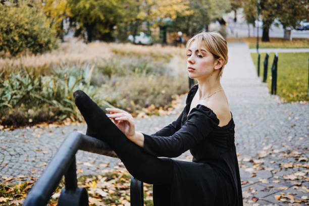 ballerine dansant dans la rue de la ville d’automne, danseuse de ballet moderne en robe noire, chaussures de pointe à l’extérieur. étirements de ballerines, routine quotidienne d’étirement de ballet - flying contemporary dancing dancer photos et images de collection