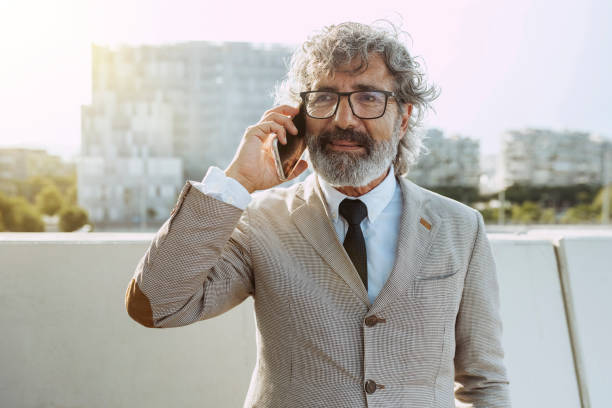 istock Senior businessman in suit talking with smartphone 1677754445
