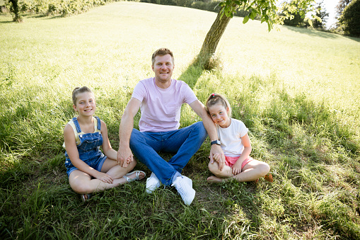 father with his two daughters outdoor in the nature