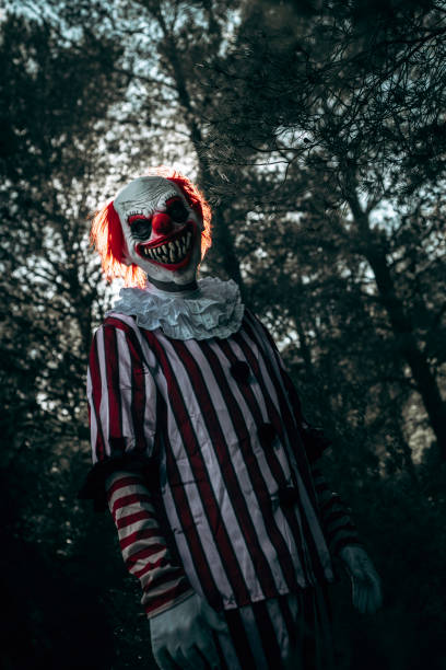 istock mad evil clown stares at the observer in the woods 1677783538