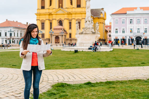 istock Young Female Tourist Reading A Map In Timisoara 1677794709