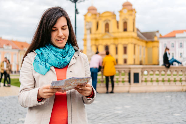 istock Young Female Tourist Reading A Map In Timisoara 1677796351