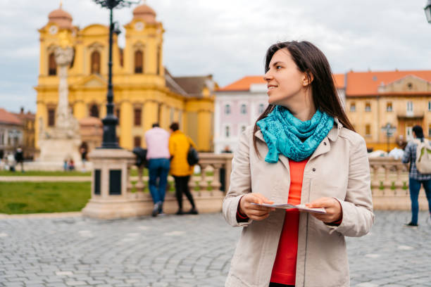 istock Young Female Tourist Reading A Map In Timisoara 1677796368