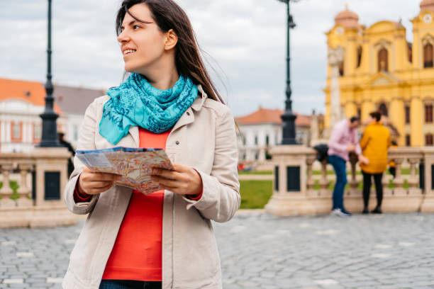istock Young Female Tourist Reading A Map In Timisoara 1677796885