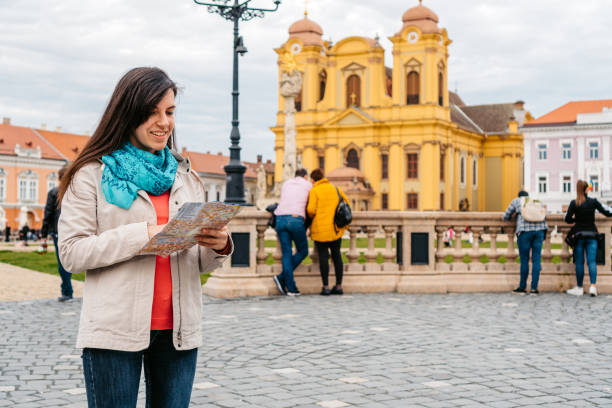 istock Young Female Tourist Reading A Map In Timisoara 1677796913