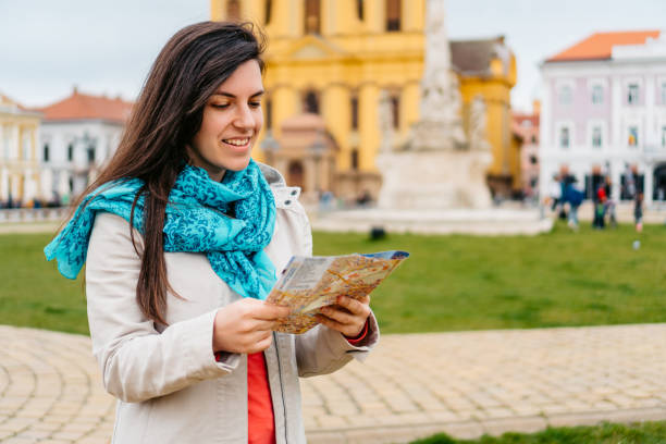 istock Young Female Tourist Reading A Map In Timisoara 1677798698