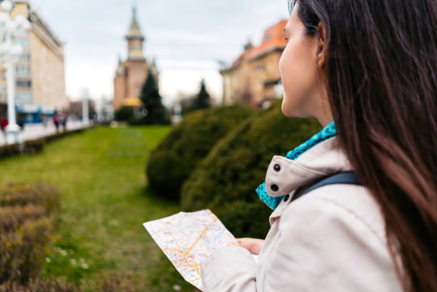 istock Young Female Tourist Reading A Map In Timisoara 1677799298
