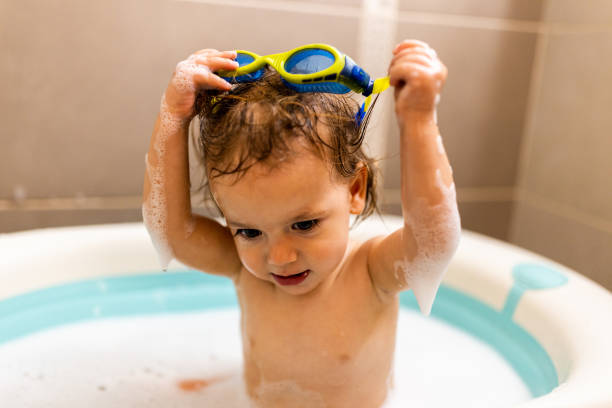 istock Girl in swimming goggles taking a bath at home 1677800431