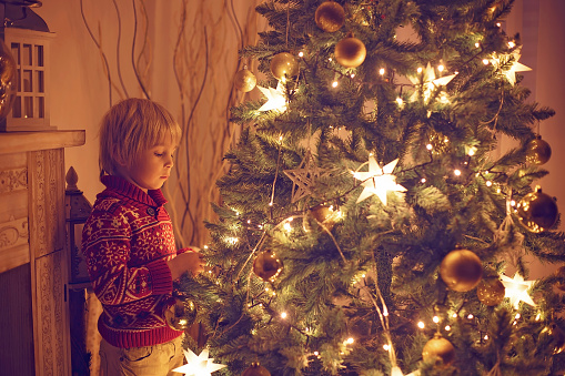 Cute child, boy, playing in a decorated room for Christmas, cozy place