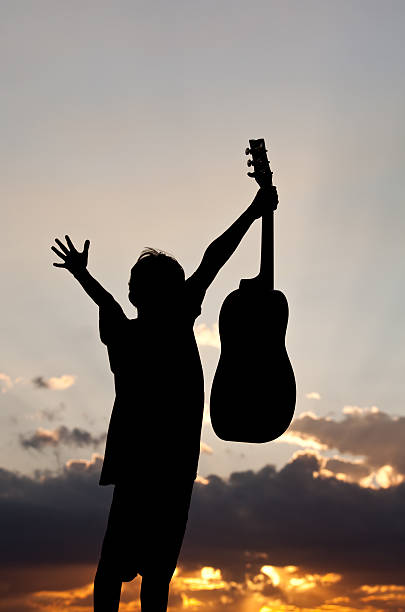 istock Silhouette of a Young Boy Holding Guitar 167783317