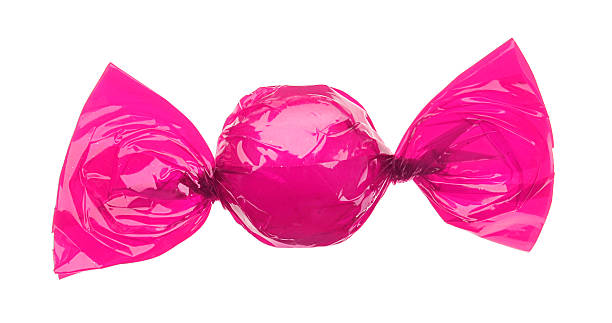 candy eingewickelt in rosa folie - süßigkeit stock-fotos und bilder
