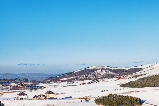 Winter landscape with settlement under the clear blue sky on Zlatibor mountain in Serbia