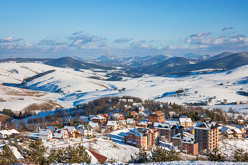 Settlement on Zlatibor mountain in Serbia, hills covered with snow on a beautiful winter day