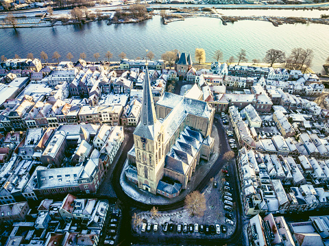 Kampen Bovenkerk seen from above during a cold winter sunrise at the start of a cold bright winter day with light snow on the roofs. View on the Church and city from an bird's eye perspective. Kampen is an ancient Hanseatic League city at the shore of the river IJssel in Overijssel, The Netherlands.