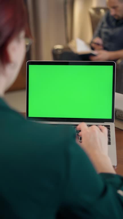 Young Girl Using Laptop with Green Mock-up Screen. Students Learning in Library