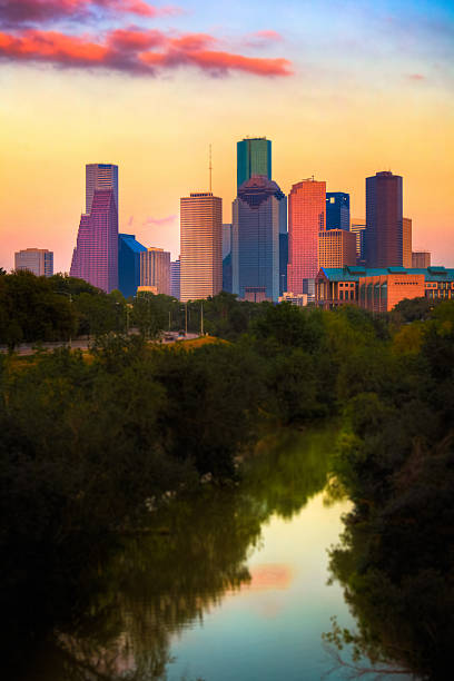 The city of Houston skyline by the water Houston Skyline at Sunset. Selective focus, tilt shift effect. Digital noise added. houston skyline stock pictures, royalty-free photos & images