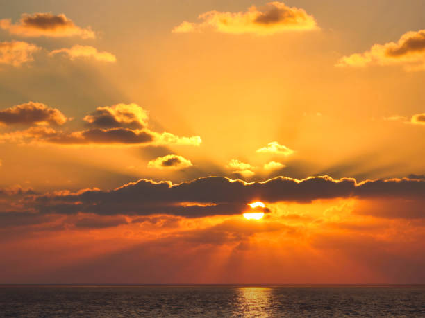 istock Glowing Clouds and Sun Rays over the Sea at Dusk 1677887644