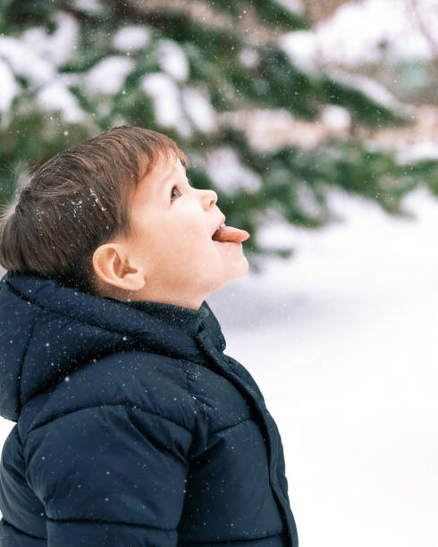 istock A child catches snowflakes with his tongue 1677896519