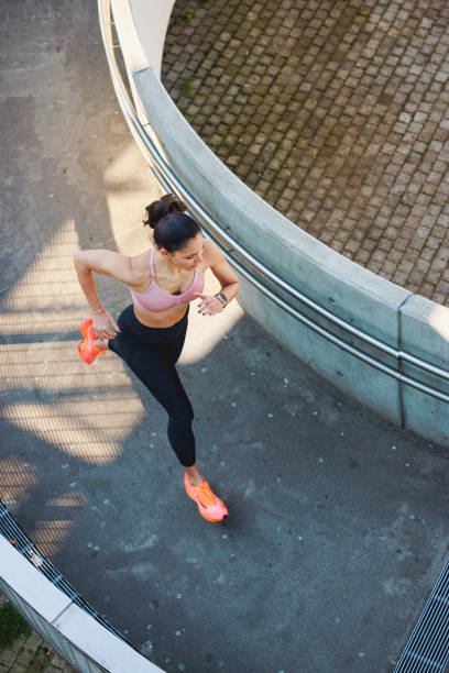 istock High angle view on active woman running up the curved walkway 1677939386