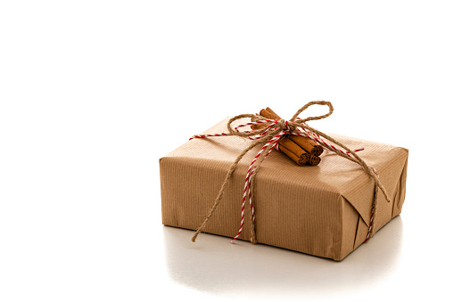 Christmas gift box wrapped with brown paper isolated on white background