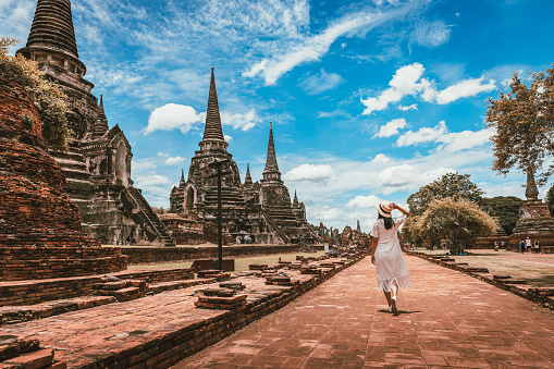 Historical local travel Thai concept, Happy traveler asian woman with dress sightseeing in Wat Phra Si Sanphet temple with pagoda background, Ayutthaya historical park, Ayutthaya, Thailand.