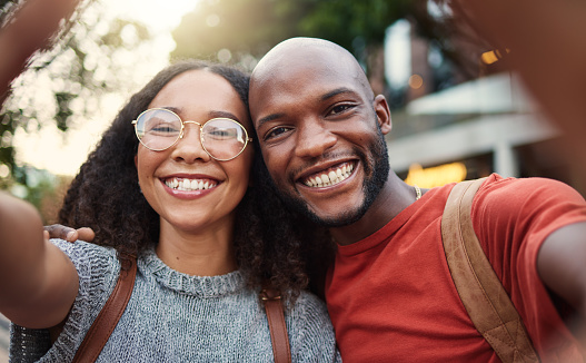 Selfie, love and smile with an interracial couple in the city together for travel, tourism or adventure overseas. Portrait, freedom or fun with a man and woman taking a photograph in an urban town