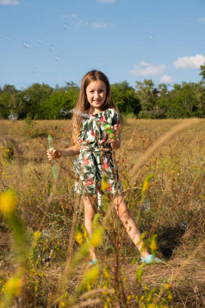 istock A five-year-old girl blows soap bubbles outdoors in a field in the summer 1677968455