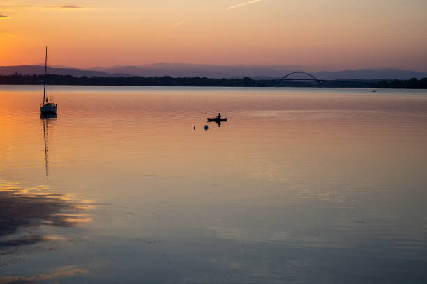 Kayak and sailboat at sunrise on Lake Champlain