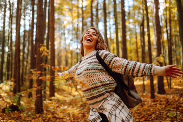 istock Tourist with a hiking backpack, hat walks along a path in the autumn forest. 1678075212