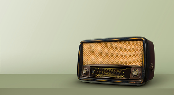 Antique radio on green table and vintage background.