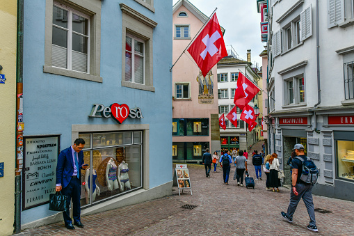 Zurich - May 15 ,2023 :Swiss flags and colorful houses in Strehlgasse streets of old Zurich, Switzerland