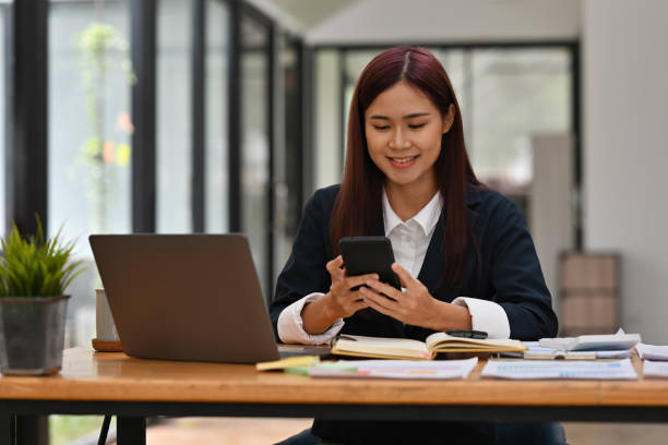 istock Businesswoman using smartphone while sitting at office desk. 1678105450