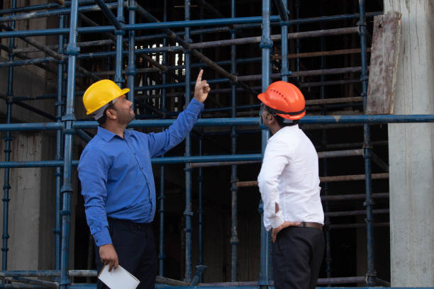 istock Two male engineers in hardhats standing on construction site and planning 1678109186