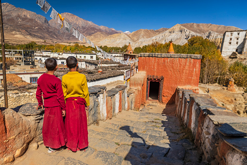 Novice Tibetan buddhist monks looking at the view in Tsarang village in Upper Mustang. Mustang region is the former Kingdom of Lo and now part of Nepal,  in the north-central part of that country, bordering the People's Republic of China on the Tibetan plateau between the Nepalese provinces of Dolpo and Manang.