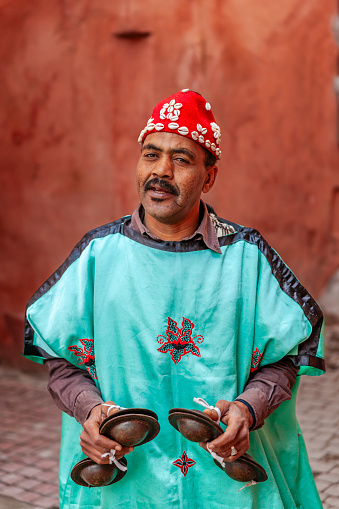 Moroccan street musician in traditional costume on Djemaa el Fna square, Marrakech, Morocco. Djemaa el Fna is a heart of Marrakesh's medina quarter.