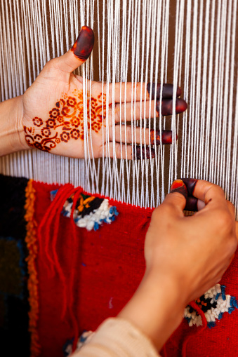 Berber woman weaving a carpet in a traditional house, Ouarzazate, Morocco. This old fashined form of weaving is very popular in the High Atlas mountains, specially in villages near Ouarzazate town.