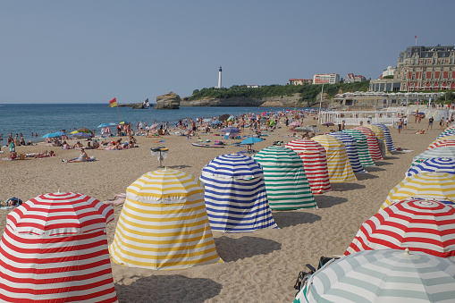 Biarritz, France - 22 July, 2022: Colorful sun shelters on the Grand Plage beach in Biarritz