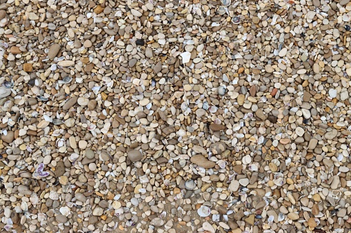 A gravel bed featuring a mix of brown, white and black rocks