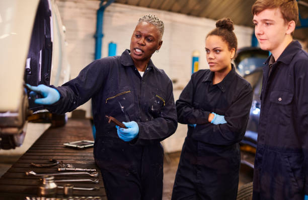 female auto mechanic tutor with students