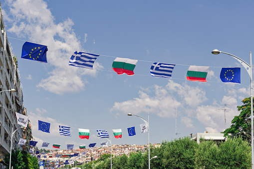 Thessaloniki, Greece - September 9 2023: Greek, Bulgarian, and European Union flags waving above a street during the 87th TIF International Fair. Bulgaria is the honoured country this year.