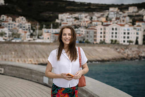Portrait of a beautiful young happy woman enjoying a lovely summer day in the city-port Lustica Bay