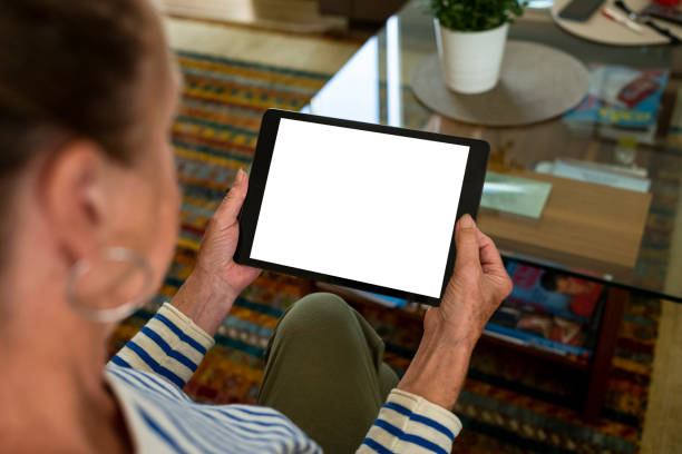 istock Elder woman hand hold tablet white screen home template 1678190922